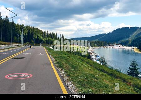 Landschaftsansicht von Radweg und Weg nur für Fußgänger. Radweg Wegweiser entlang Bergwald See Resort Stockfoto