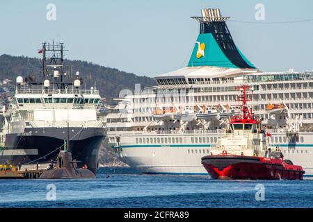 BERGEN, NORWEGEN - 20. Mai 2015: Bergen, Norwegen, 2015. Mai: Hafenszene in Bergen, Norwegen, mit Kreuzfahrtschiff und Schleppboot und U-Boot Stockfoto