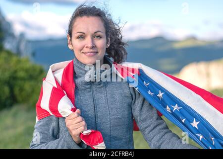 Amerikanischer Nationalfeiertag. Junge Frau mit US-Flagge mit amerikanischen Sternen, Streifen und nationalen Farben. Unabhängigkeitstag. Juli. Stockfoto