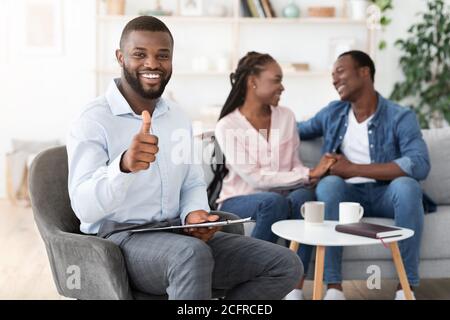 Erfolgreiche Therapie. Psychologe Gestiking Daumen Nach Oben Während Glücklich Paar Bonding Auf Couch Stockfoto