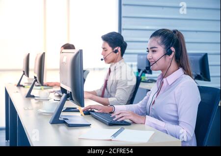 Junge Kundendienstmitarbeiterinnen mit Headsets und Computer arbeiten im Büro. Professionelles Bedienkonzept. Stockfoto
