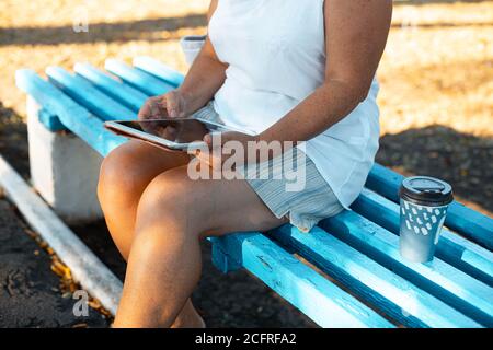 Freelancer blonde Geschäftsfrau mit Tablet im Park im Freien. Stockfoto