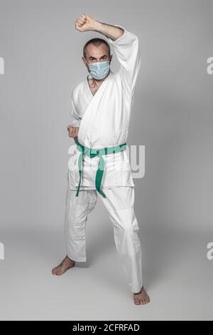 Mann übt Kampfkunst trägt eine chirurgische Maske zu trainieren Sicher zum Zeitpunkt der covid 19 Stockfoto