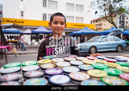 Kota Kinabalu / Malaysia - 13. Januar 2019: Kleiner Junge, der Schuhcreme am Straßenstand verkauft Stockfoto