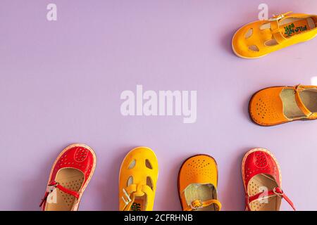 Stylische neue gelbe und rote Schuhe auf farbigem pastellfarbenem Hintergrund mit Copyspace, Draufsicht, flacher Lay Stockfoto