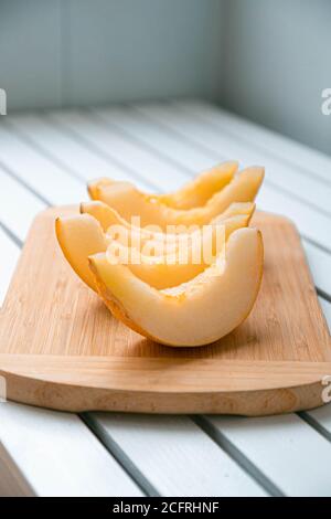 Bunte reife Früchte Muster Melonenscheiben auf weiß auf dem Holztisch. Sommerliches Fruchtkonzept. Vertikales Foto Stockfoto