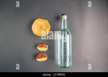 Draufsicht auf Flasche kristallinen Tequila oder Mezcal mit Jicaras und würzige Orangen Stockfoto