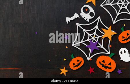 halloween Hintergrund. Kürbis, Fledermäuse und Spinne Schnitt aus Papier auf schwarzem Holz. Platz für Text Stockfoto