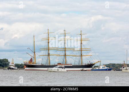 Hollern-Twielenfleth, Deutschland - 7. September 2020: Historische Barke PEKING an der Elbe wird mit einem Polizeiboot und Zuschauern auf kleinen Booten zum Deutschen Hafenmuseum in Hamburg geschleppt Stockfoto