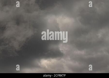 Stürmische Wolken in verschiedenen Grautönen, die den Himmel vollständig bedecken. Stockfoto