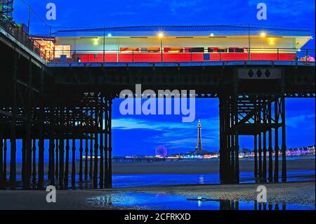 Der Central Pier und der Blackpool Tower sind während der Abendbeleuchtung vom South Pier aus zu sehen Stockfoto