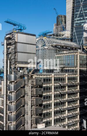 Erhöhter Blick auf den Aufzugsturm und das Atrium mit blauen Reinigungskranen und Wendeltreppen. Leadenhall Gebäude nur sichtbar in der oberen rechten Sectio Stockfoto