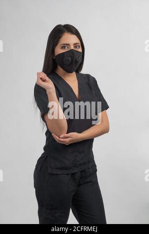 Krankenschwester in schwarz gekleidet mit Maske, Studio mit grauem Hintergrund Stockfoto