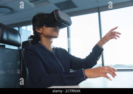 Geschäftsfrau mit Virtual-Reality-Headset im modernen Büro Stockfoto
