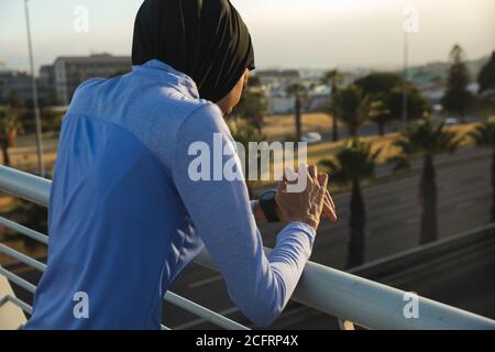 Frau in Hijab mit Smartwatch auf einem Steg Stockfoto