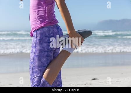 Niedriger Abschnitt der Frau, die Stretching-Übung am Strand Stockfoto