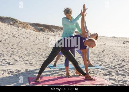 Yoga-Lehrer Yoga für Frauen am Strand Stockfoto