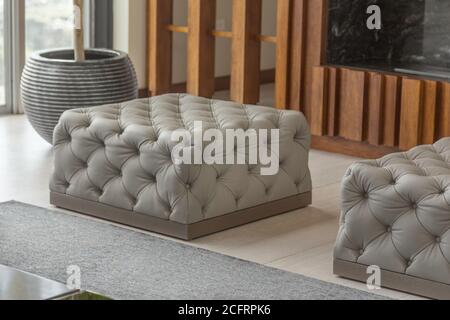 Grauer dekorativer Pouf im Wohnzimmer, Innenarchitektur Stockfoto
