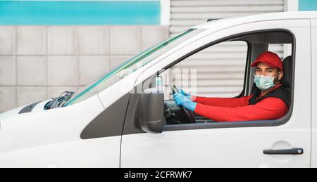 Delivery man fährt einen Van während Coronavirus Ausbruch - Courier Gesichtsschutzmaske und Handschuhe für Covid 19 Spread Prävention Stockfoto