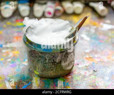 Künstlerpinsel in einem sprudelnden Behälter mit Wasser Stockfoto