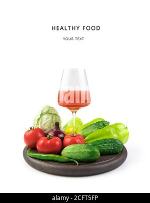 Frisches Gemüse und ein Glas frisch gepresster Saft auf weißem Hintergrund. Stockfoto