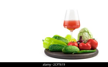 Frisches Gemüse in einer großen Auswahl mit einem Glas frisch gepressten Saft auf weißem Hintergrund mit einem Platz zum Kopieren. Stockfoto