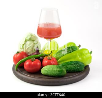 Ein Glas frisch gepresster Gemüsesaft und eine große Auswahl an frischem Gemüse auf einem runden Tablett Stockfoto