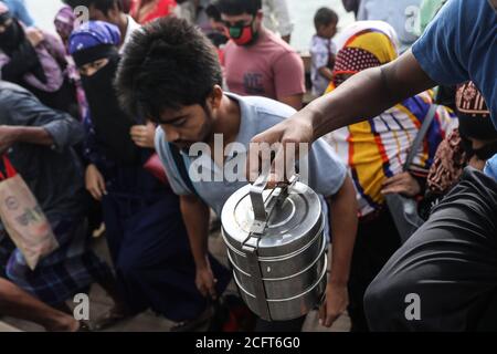 Dhaka, Bangladesch. September 2020. Ein Bekleidungsarbeiter trägt eine Lunchbox, um während der Coronavirus-Pandemie zu arbeiten. Nach Angaben der Industriepolitik haben bereits über 20,000 Bekleidungsarbeiter in Bangladesch zum 22. Juni 2020 ihren Arbeitsplatz verloren. Die Menschen in der Bekleidungsindustrie sagen, dass die Zahl steigen wird, wenn die Besitzer aufgrund eines Mangels an Arbeitsaufträgen zurückgehen. Kredit: SOPA Images Limited/Alamy Live Nachrichten Stockfoto