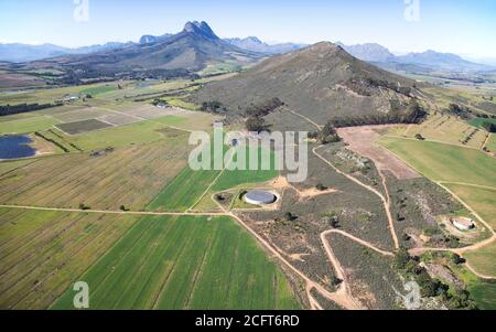 Kapstadt, Westkap / Südafrika - 08/26/2020: Luftaufnahme von landwirtschaftlichen Feldern und Klapmuts Koppie Stockfoto