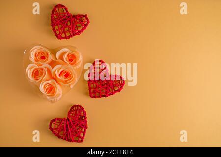 Rote Herzen aus Zweigen von Reben und Rosen auf beigem Hintergrund. Grußkarten-Design zum Valentinstag. Für Text platzieren. Stockfoto