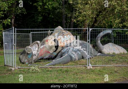 Berlin, Deutschland. September 2020. Mehrere zerbrochene Dinosaurierfiguren liegen eingezäunt im Spreepark im Plänterwald. 2014 hat das Land Berlin das Erbbaurecht für den Spreepark zurückgekauft und will dort den verwaisten Spreepark wieder beleben.Quelle: Fabian Sommer/dpa/Alamy Live News Stockfoto