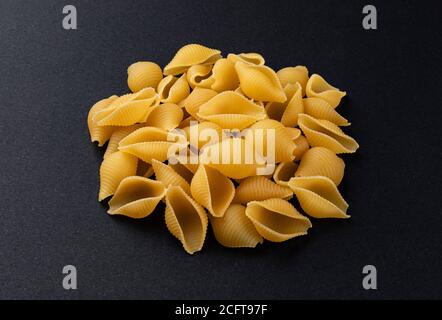 Conchiglie rigate. Roh gestreifte Muschel Pasta auf schwarzem Hintergrund Stockfoto