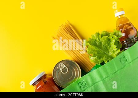 Lieferung der notwendigen Nahrung während der Quarantäne. Spende Lebensmittel auf gelbem Hintergrund, Platz für Ihren Text. Stockfoto
