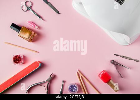 Ein Set von Werkzeugen für Maniküre und Nagelpflege auf einem rosa Hintergrund. Arbeitsplatz in einem Schönheitssalon. Für Text platzieren. Stockfoto