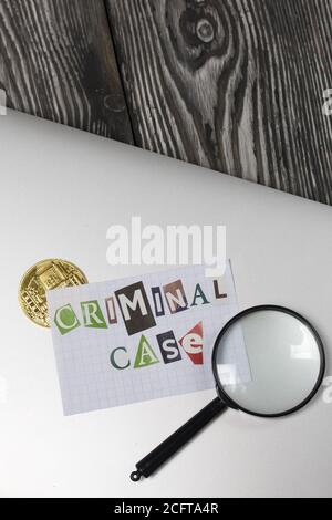 Die Phrase Criminal Case aus Buchstaben aus einer Zeitschrift geschnitten und auf einem Blatt Papier geklebt. Das Blatt mit der Aufschrift liegt auf dem Laptop-Cover. Stockfoto