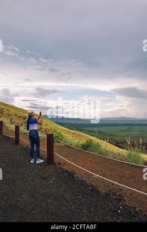 Eine junge Frau, die mit dem Smartphone Bilder von der Landschaft fotografiert masaya Vulkan Nationalpark Stockfoto