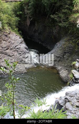 Ein Gebirgsbach, der auf dem Pipiwai Trail im Regenwald von Kipahulu, Maui, Hawaii, USA, durch vulkanisches Gestein stürzt Stockfoto