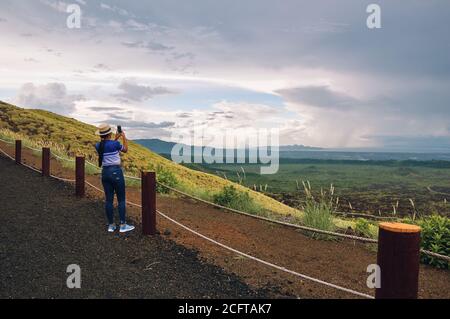 Eine junge Frau, die mit dem Smartphone Bilder von der Landschaft fotografiert masaya Vulkan Nationalpark Stockfoto