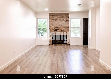 Leeres Wohnzimmer mit Kamin, weißen Wänden und Holzboden Stockfoto