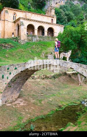 Alte Kapelle, Brücke und eine Frau Tourist mit einem Hund. Stockfoto