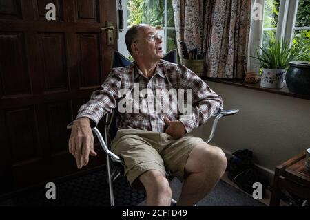 Ältere Paar saß in ihrer Veranda soziale Distanzierung zu Hause während der Coronavirus Pandemie Lockdown, Wales, Vereinigtes Königreich Stockfoto