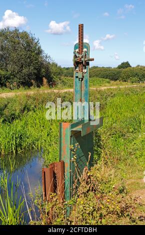 Ein Verschnitt mit Schleusentor, das Wasser aus dem North Walsham und Dilham Canal nördlich der Royston Bridge, North Walsham, Norfolk, England, UK leitet. Stockfoto