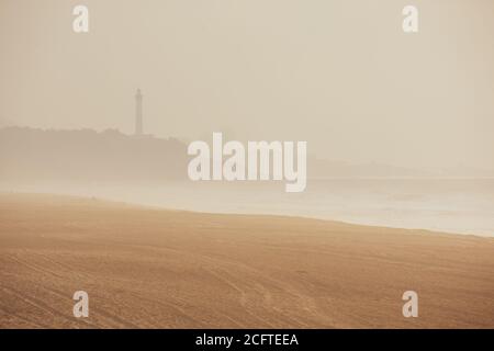 Nebel ('brouillarta') am Strand von Anglet, Frankreich. Leuchtturm von Biarritz im Hintergrund Stockfoto