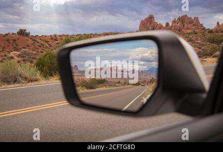 Ein Blick auf die Felsformationen im Rückspiegel Eines Autos, das im Arches Nationalpark fährt Stockfoto
