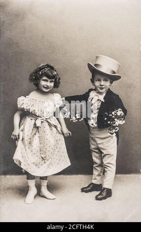Foto von lustigen kleinen Mädchen und Jungen im Vintage-Dressing. Retro-Bild mit Original-Film Maserung und Kratzer Stockfoto