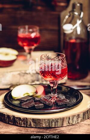 Glas hausgemachter Johannisbeere Naliwka mit Apfelscheiben und Schokolade Stockfoto