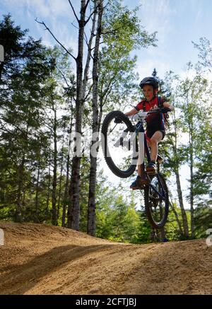 Ein kleiner Junge (8 Jahre alt) Springen auf seinem Mountainbike Stockfoto