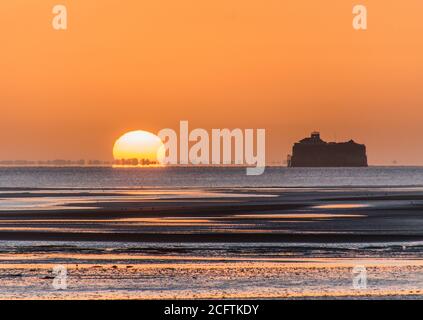 Solent Sunrise. Die Sonne geht neben dem No man's Land Fort im Solent auf, fotografiert vom Ryde Pier, Isle of Wight Stockfoto