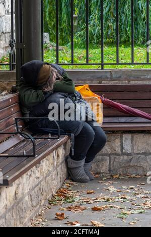 Eine obdachlose Dame schläft schnell auf einer Bank im Zentrum der Stadt york. Stockfoto