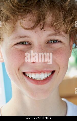 Nahaufnahme Porträt von Rotschopf lächelnd Junge mit Sommersprossen, hat Teenager-Junge perfekt toothy Lächeln Stockfoto